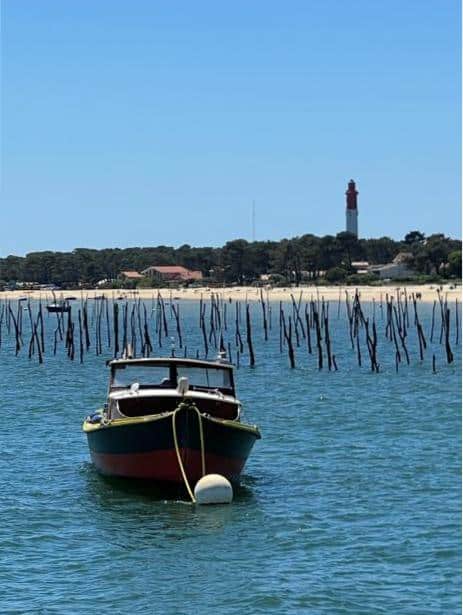 Boat on water with distant lighthouse view.